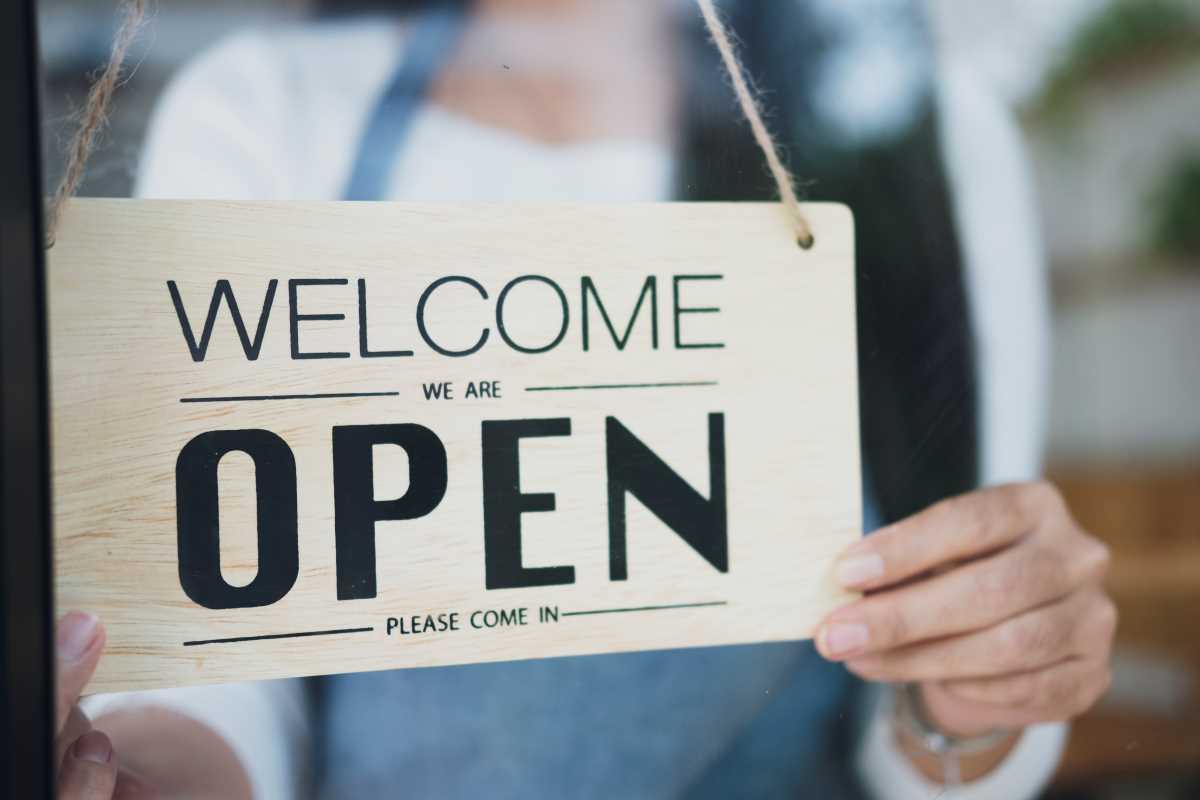 close up of woman hands holding an open sign