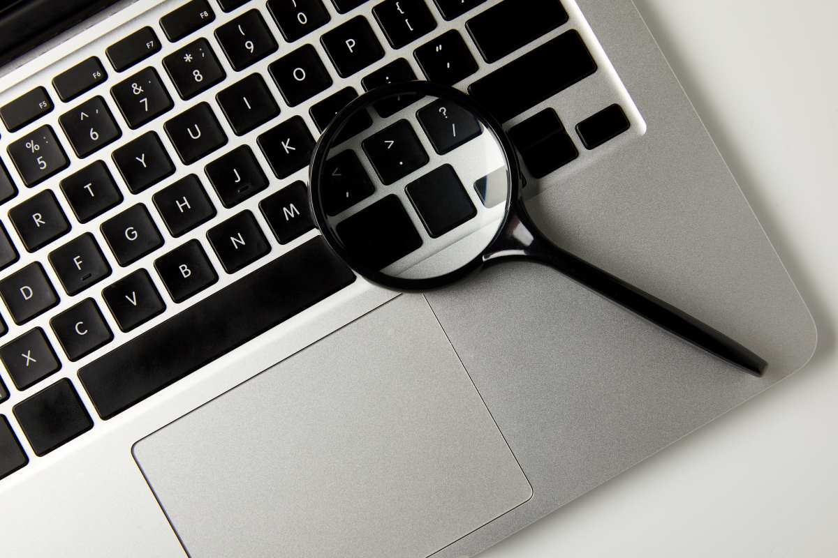 top view of magnifying glass and laptop