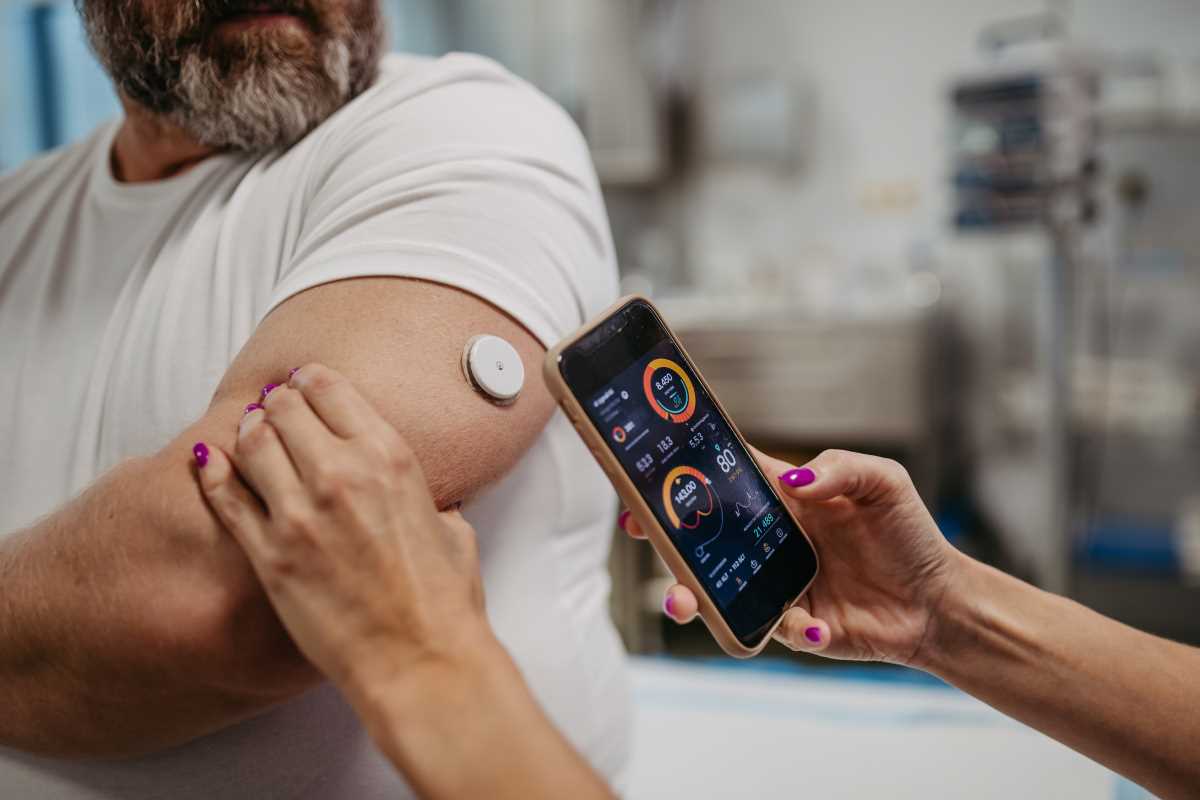 doctor connecting continuous glucose monitor-